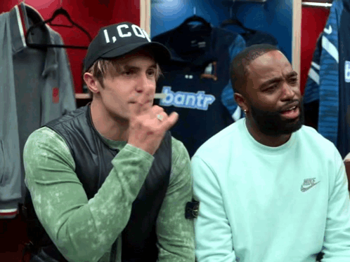 Two Men In A Locker Room One Wearing A Hat That Says Ico GIF