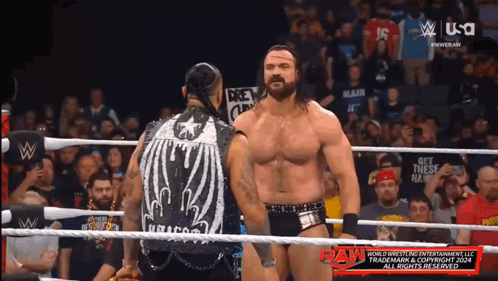 Two Men In A Wrestling Ring With A Sign That Says " Get These Hands " On It GIF