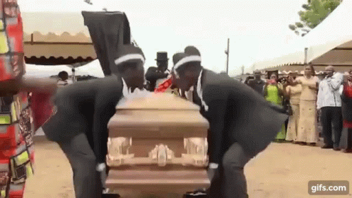 Two Men In Black Suits Dancing Around Coffin GIF
