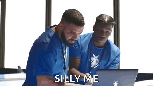 Two Men in Blue Scrubs Looking at Laptop