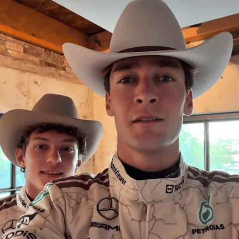 Two Men in Cowboy Hats and Petronas Shirts Posing