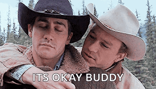 Two Men In Cowboy Hats Are Hugging Each Other And The Words `` It 'S Okay Buddy '' Are Above Them . GIF