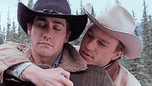 Two Men In Cowboy Hats Are Hugging Each Other With Their Eyes Closed . GIF