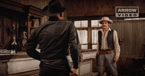 Two Men In Cowboy Hats With Arrow Banner GIF