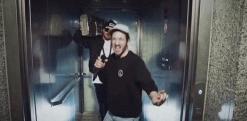 Two Men In Elevator One In Black Mercedes Shirt GIF