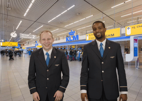 Two Men in Front of KLM Sign
