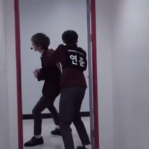 Two Men in Front of Mirror One Wearing Tomorrow Shirt