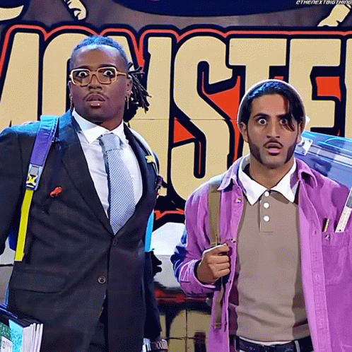 Two Men in Front of Monsters Sign