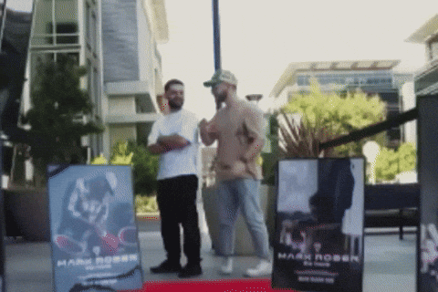 Two Men in Front of Sign Saying Mark Robin