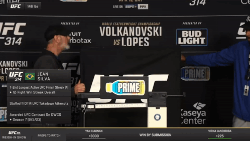 Two Men in Front of UFC 314 Sign