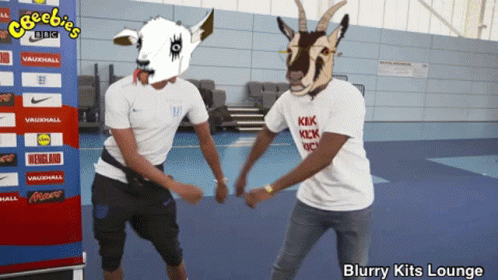 Two Men in Goat Masks Dancing in Front of Cheebies BBC Banner