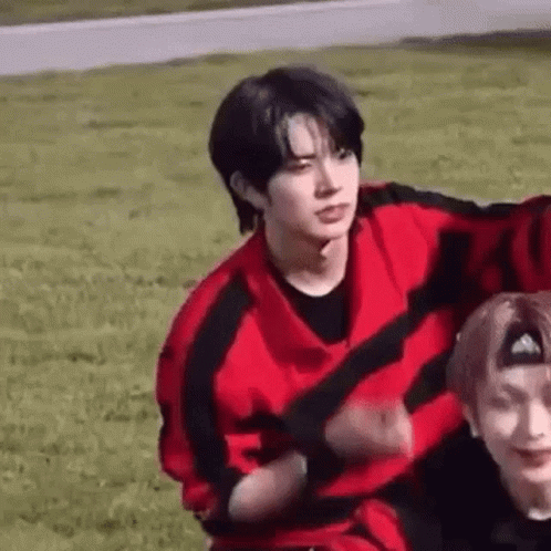Two Men in Grassy Field Man in Red and Black Sweater