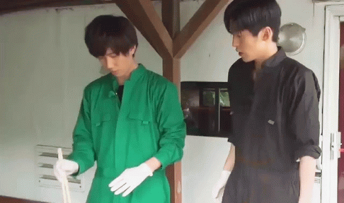 Two Men In Green Jumpsuits And White Gloves Are Standing Next To Each Other . GIF