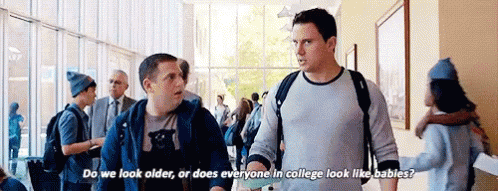 Two Men In Hallway Asking About College Looks GIF
