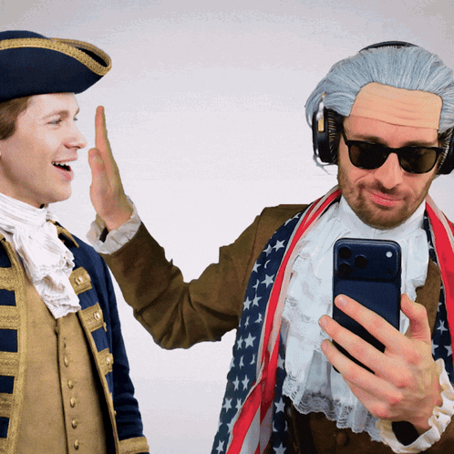 Two Men in Historical Costumes High Five One on Phone