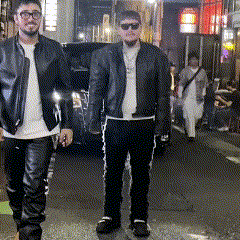 Two Men In Leather Jackets Are Walking Down The Street GIF