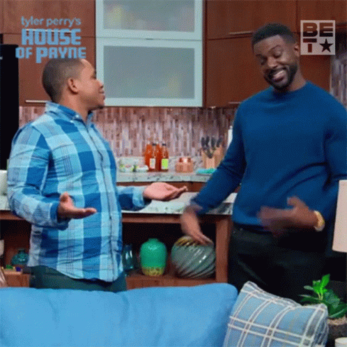 Two Men in Living Room With Tyler Perry's House of Payne Background
