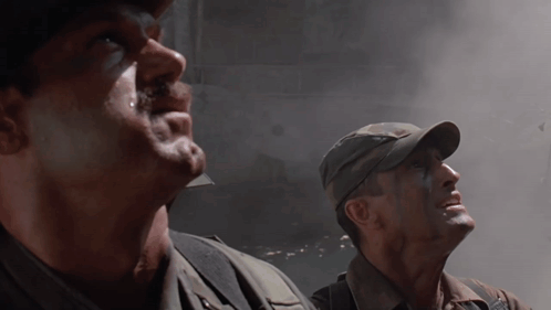 Two Men In Military Uniforms Are Looking Up At The Sky GIF