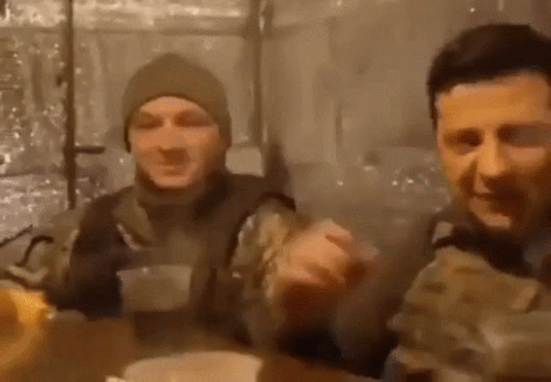 Two Men In Military Uniforms Are Sitting At A Table And Eating Food . GIF