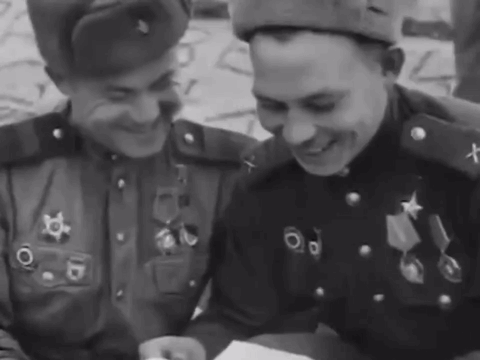 Two Men In Military Uniforms Are Smiling And Looking At Something GIF