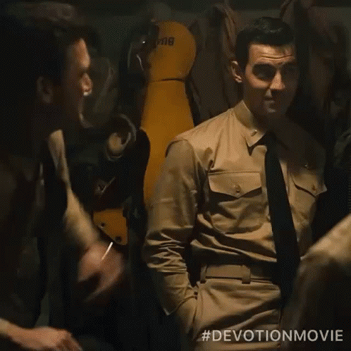 Two Men In Military Uniforms Are Standing Next To Each Other And One Has A Cigarette In His Mouth . GIF