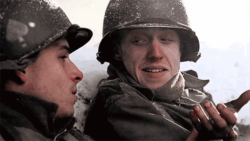 Two Men In Military Uniforms Are Talking To Each Other In The Snow . GIF