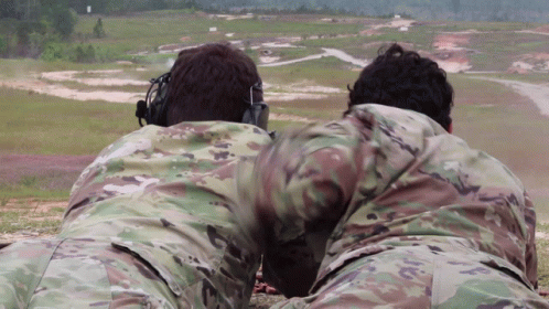 Two Men In Military Uniforms Lying In Field GIF