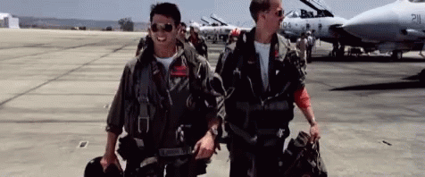 Two Men In Military Uniforms Walking On Runway In Front Of Jet GIF