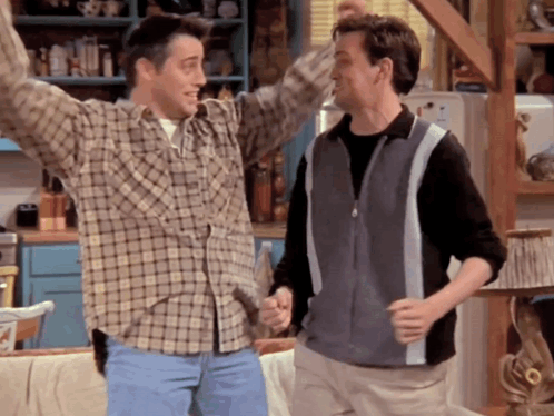 Two Men In Plaid Shirts Are Dancing Together GIF