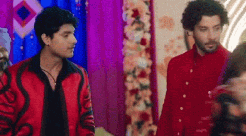 Two Men in Red Jackets Near Flower Arrangement