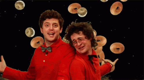 Two Men In Red Shirts And Bow Ties Are Surrounded By Donuts GIF