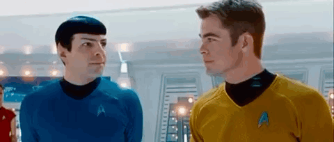 Two Men In Star Trek Uniforms Looking At Each Other GIF