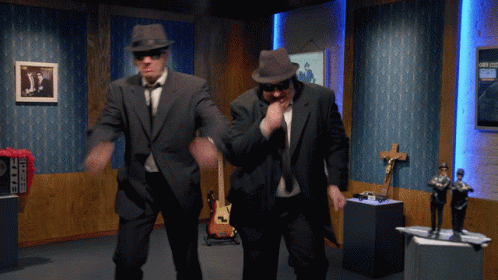 Two Men In Suits And Hats Are Dancing In A Room With A Sign That Says ' A ' On It GIF
