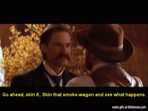 Two Men In Suits And Hats Are Talking To Each Other And The Caption Says Go Ahead Skin It GIF
