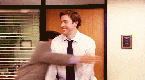 Two Men In Suits And Ties Are Hugging Each Other In An Office . GIF