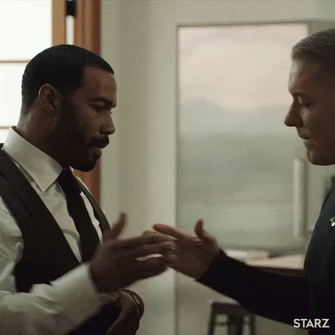 Two Men In Suits And Ties Are Shaking Hands In A Starz Advertisement . GIF