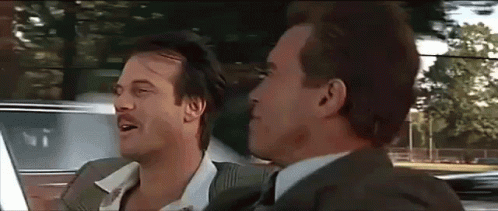 Two Men In Suits And Ties Are Sitting In A Car And Talking To Each Other . GIF