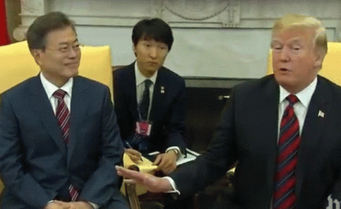 Two Men In Suits And Ties Are Sitting Next To Each Other Talking . GIF