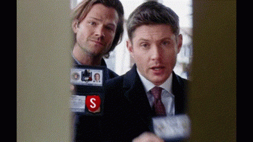 Two Men In Suits And Ties Are Standing Next To Each Other And One Of Them Has A Badge That Says S On It . GIF