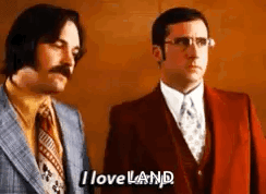 Two Men In Suits And Ties Are Standing Next To Each Other And One Of Them Is Saying `` I Loveland '' . GIF