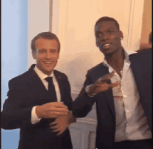 Two Men In Suits And Ties Are Standing Next To Each Other And Smiling GIF