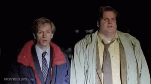 Two Men In Suits And Ties Are Standing Next To Each Other In The Dark And Looking Up . GIF