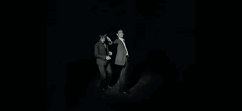 Two Men In Suits And Ties Are Standing Next To Each Other With Their Arms Outstretched . GIF