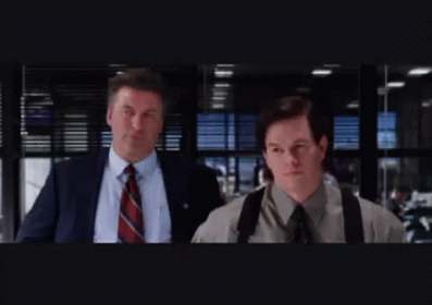 Two Men In Suits And Ties Are Walking In A Dark Room GIF