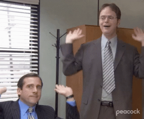Two Men In Suits And Ties Are Waving Their Hands In Front Of A Peacock Logo . GIF