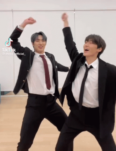 Two Men in Suits and Ties Dancing Hands in Air
