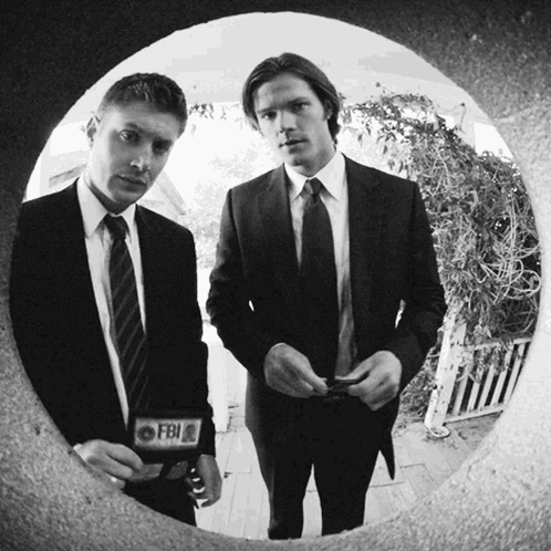 Two Men In Suits And Ties With A Fbi Badge On Their Jacket GIF