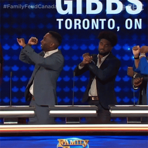 Two Men In Suits Are Dancing In Front Of A Sign That Says Toronto On It GIF