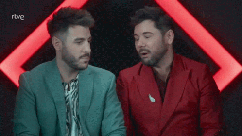 Two Men In Suits Are Sitting Next To Each Other With The Letters Rtve Visible GIF