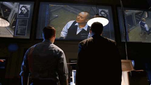 Two Men In Suits One Wearing James Name Tag GIF